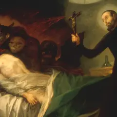 Ein Priester hält ein Kruzifix, um Dämonen von einem kranken Mann fernzuhalten. Dies zeigt, was ist Exorzismus: ein Kampf gegen das Böse.
