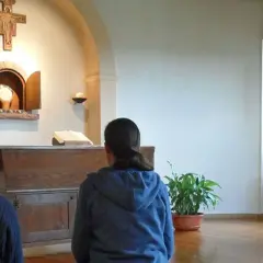Drei Frauen, vielleicht kleine Schwestern Jesu, beten in einer Kapelle vor dem Altar.