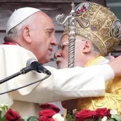 Papst Franziskus umarmt Patriarch Kyrill, der eine prunkvolle Kopfbedeckung trägt. Ein Moment der ökumenischen Annäherung.