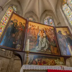 Der Marienaltar im Naumburger Dom zeigt Maria mit Kind, umgeben von Heiligen und Engeln, unter farbenprächtigen Glasfenstern.