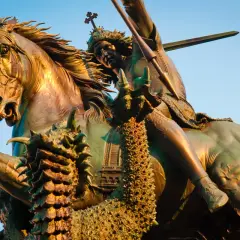 Bronzestatue: der heilige georg auf seinem Pferd, der einen Drachen mit einer Lanze tötet.