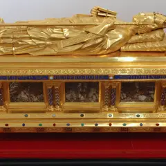 Goldener Schrein mit liegender Figur, vielleicht die teuerste Reliquie der Welt, verziert mit Edelsteinen und Inschriften.