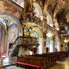 Prachtvoller barocker Innenraum des Stifts Vorau mit kunstvollem Altar, bemalter Decke und Kirchenbänken.