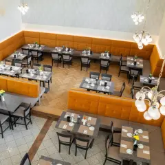 Gemütliche Tische mit Blumenarrangements im Speisesaal des **Pallottiner Salzburg**.
