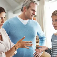 Ein ernstes Gespräch zwischen Eltern und Teenager. Die Mutter gestikuliert, der Vater schaut besorgt. Ein typischer **Streit in der Familie**.