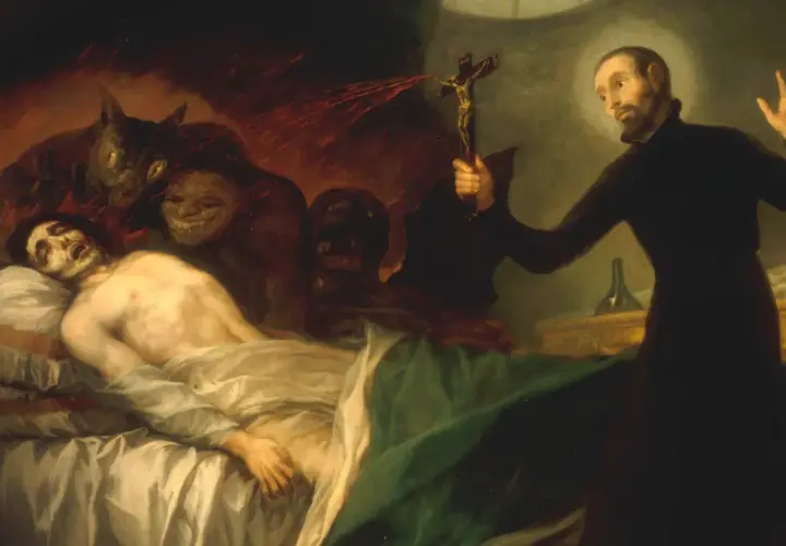 Ein Priester hält ein Kruzifix, um Dämonen von einem kranken Mann fernzuhalten. Dies zeigt, was ist Exorzismus: ein Kampf gegen das Böse.