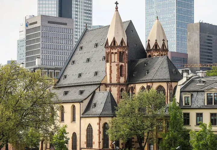 Die Kirche St. Leonhard, ein historisches Juwel, steht im Kontrast zu modernen Hochhäusern.