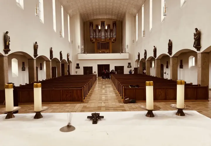 Innenraum der Kirche St. Konrad Aubing mit Bänken, Orgel und Statuen.