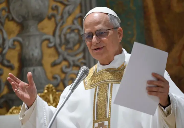Ein Mann in päpstlicher Kleidung, der wie Papst Leo aussieht, hält ein Blatt Papier und spricht ins Mikrofon.