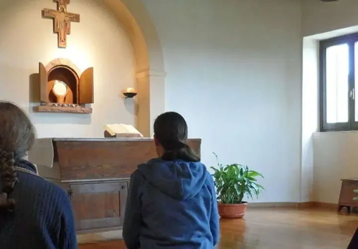 Drei Frauen, vielleicht kleine Schwestern Jesu, beten in einer Kapelle vor dem Altar.