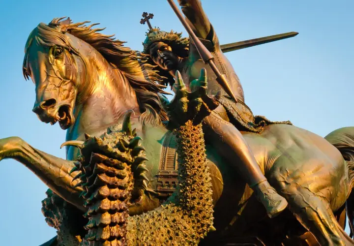 Bronzestatue: der heilige georg auf seinem Pferd, der einen Drachen mit einer Lanze tötet.