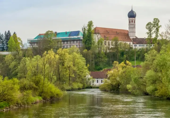 Kloster Beuerberg thront über dem Fluss, umgeben von üppigem Frühlingsgrün. Ein Teil des Klosters wird renoviert.