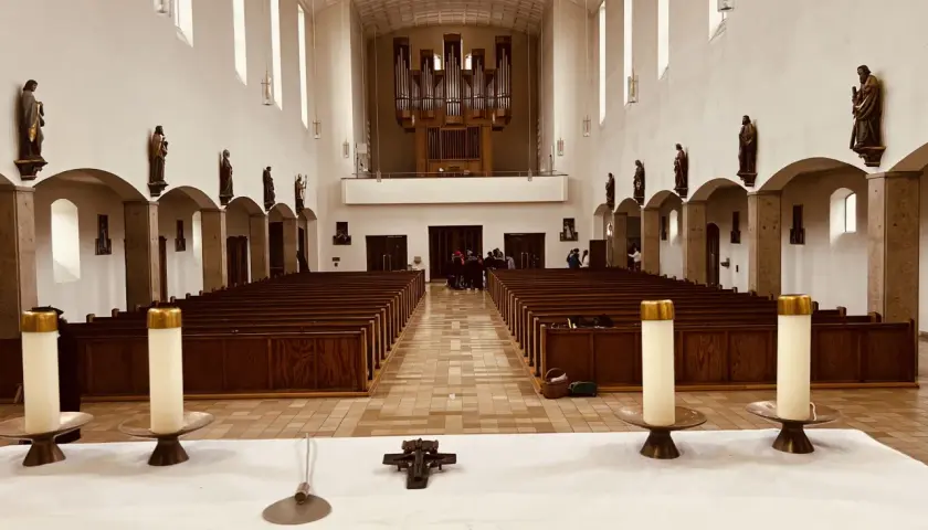 Innenraum der Kirche St. Konrad Aubing mit Bänken, Orgel und Statuen.