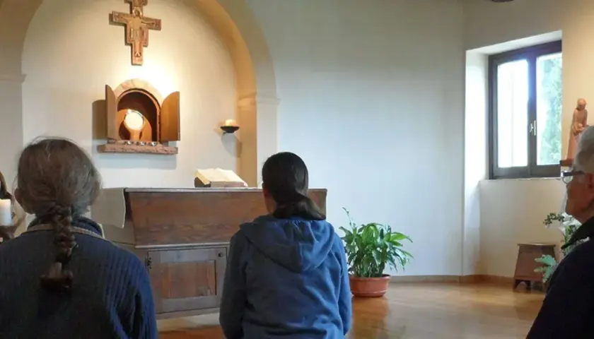 Drei Frauen, vielleicht kleine Schwestern Jesu, beten in einer Kapelle vor dem Altar.