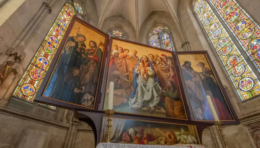 Der Marienaltar im Naumburger Dom zeigt Maria mit Kind, umgeben von Heiligen und Engeln, unter farbenprächtigen Glasfenstern.