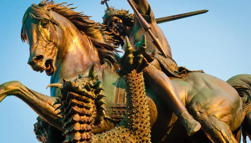 Bronzestatue: der heilige georg auf seinem Pferd, der einen Drachen mit einer Lanze tötet.