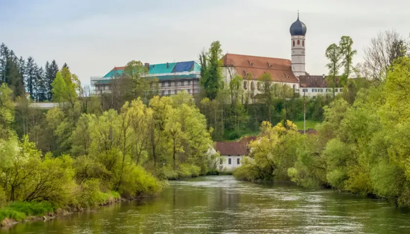 Kloster Beuerberg thront über dem Fluss, umgeben von üppigem Frühlingsgrün. Ein Teil des Klosters wird renoviert.