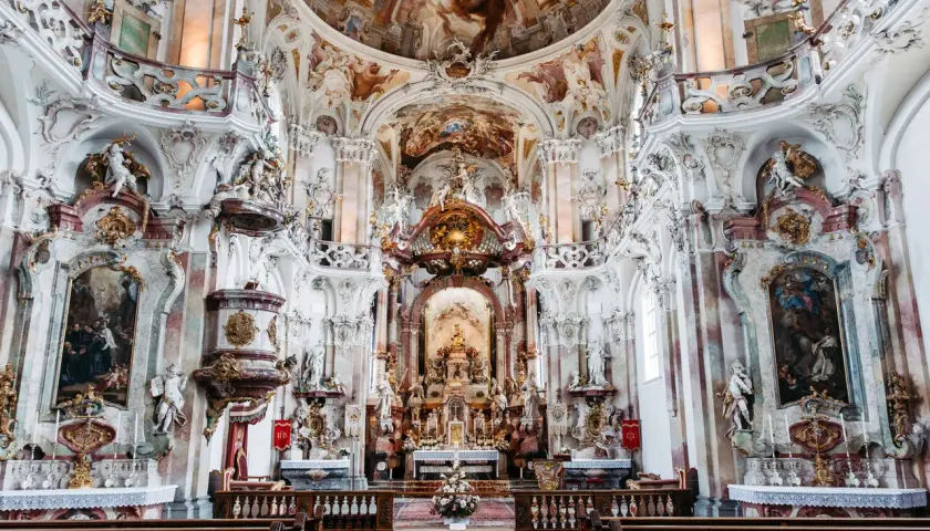 Prunkvolle Barockkirche im Kloster Mehrerau mit detailreichen Stuckaturen, Fresken und goldenen Verzierungen.
