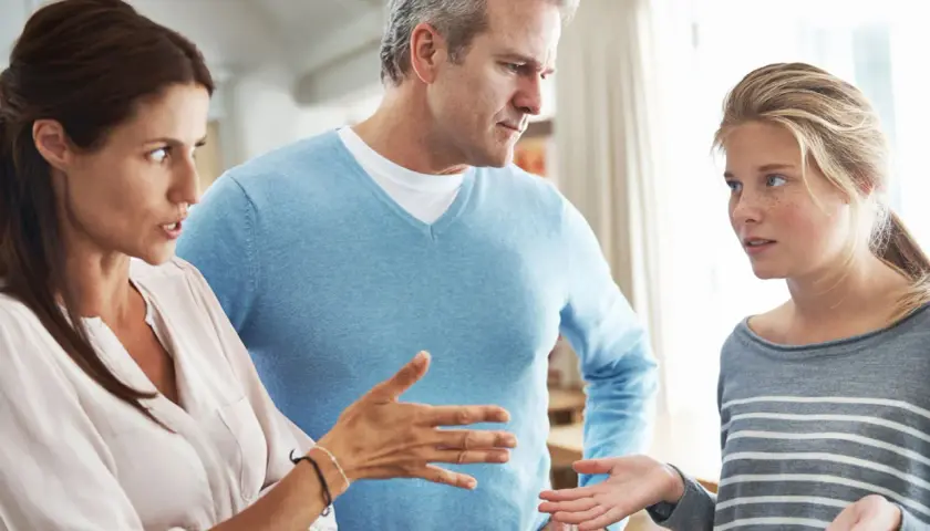 Ein ernstes Gespräch zwischen Eltern und Teenager. Die Mutter gestikuliert, der Vater schaut besorgt. Ein typischer **Streit in der Familie**.