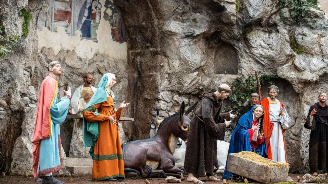 Maria und Josef in einer Krippenszene. Mönche und ein Esel sind ebenfalls zu sehen.