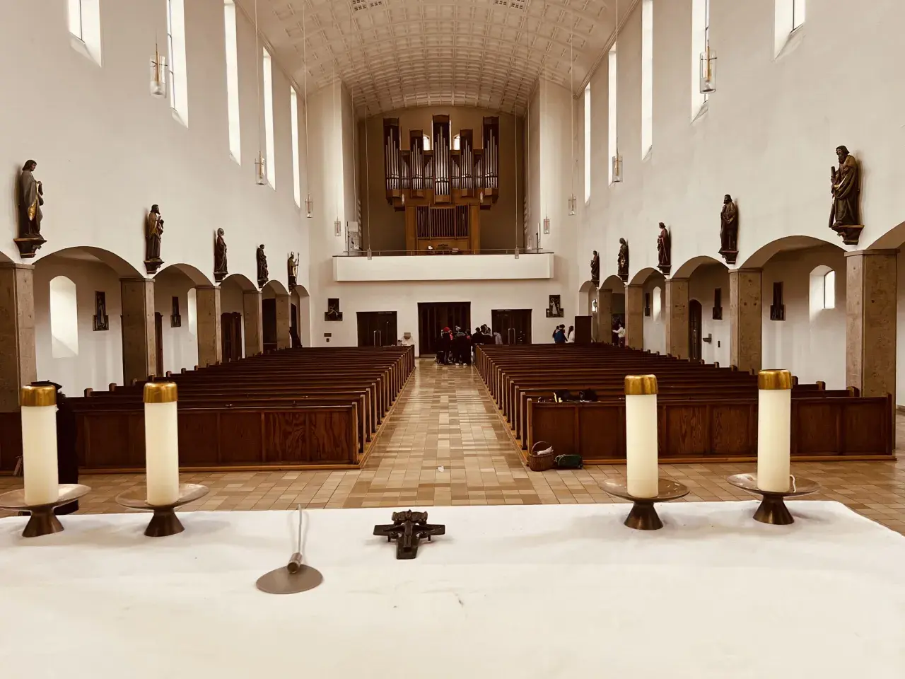Innenraum der Kirche St. Konrad Aubing mit Bänken, Orgel und Statuen.