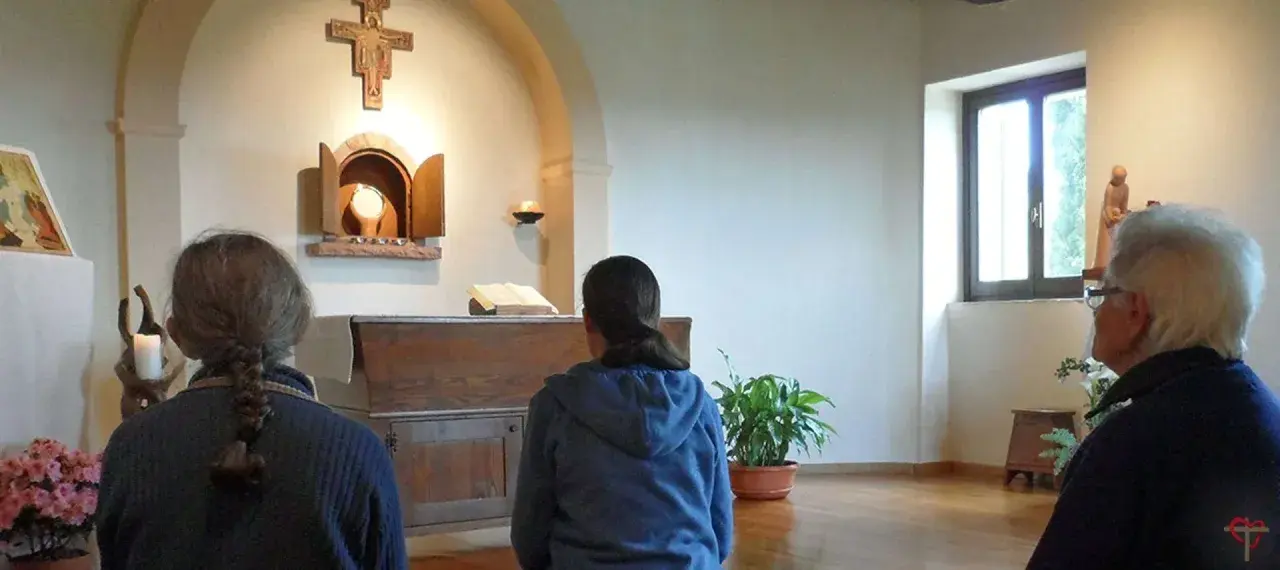 Drei Frauen, vielleicht kleine Schwestern Jesu, beten in einer Kapelle vor dem Altar.