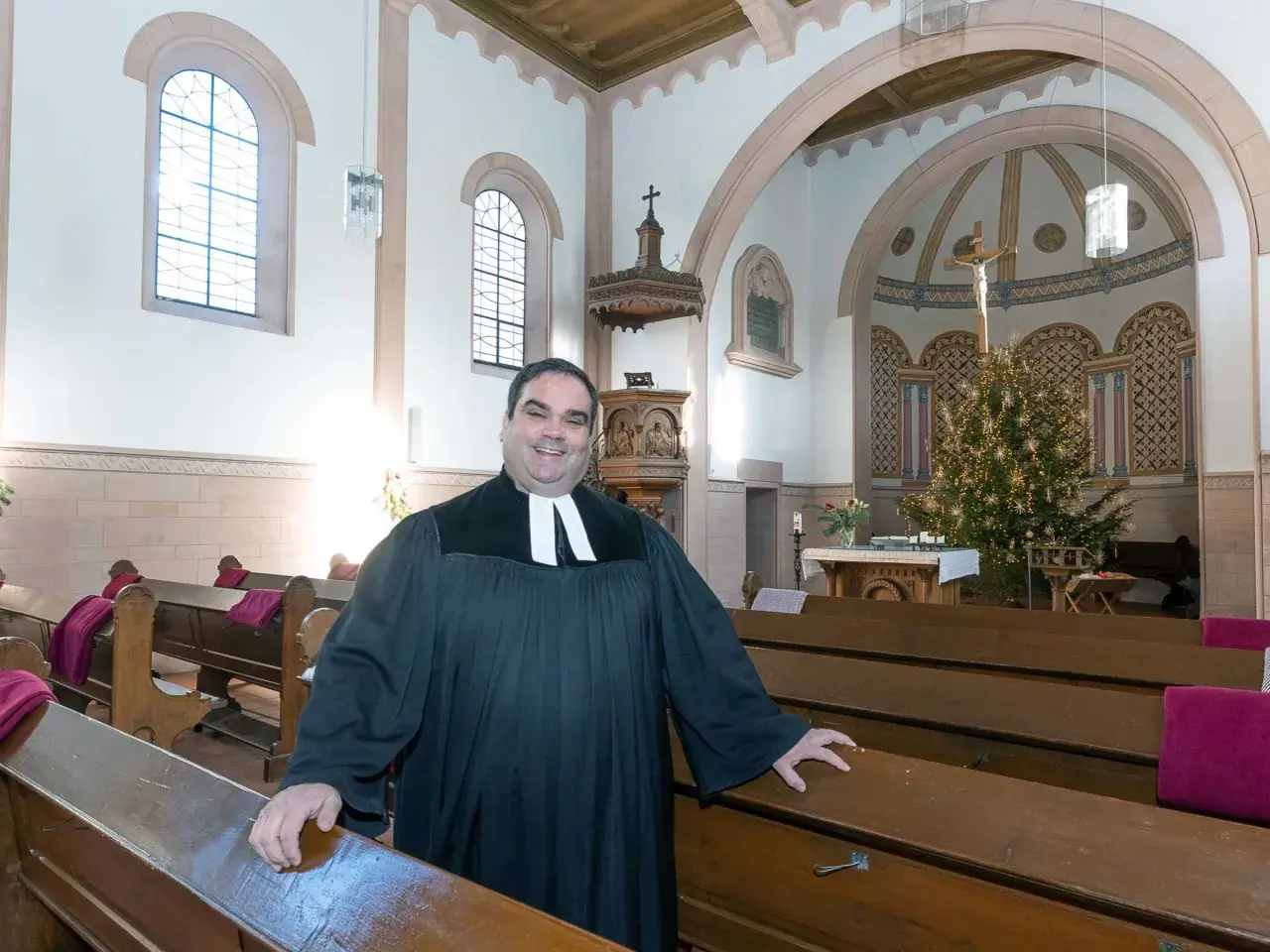 Ein Geistlicher in der Kirche, der die Bänke zeigt. Er wirkt freundlich, als würde er die Bedeutung von Gemeinschaft und Glauben erklären, im Gegensatz zur simonie definition.