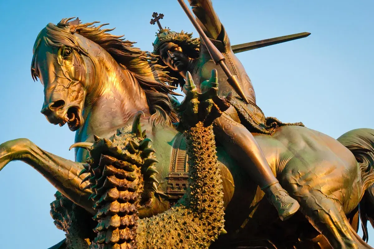 Bronzestatue: der heilige georg auf seinem Pferd, der einen Drachen mit einer Lanze tötet.
