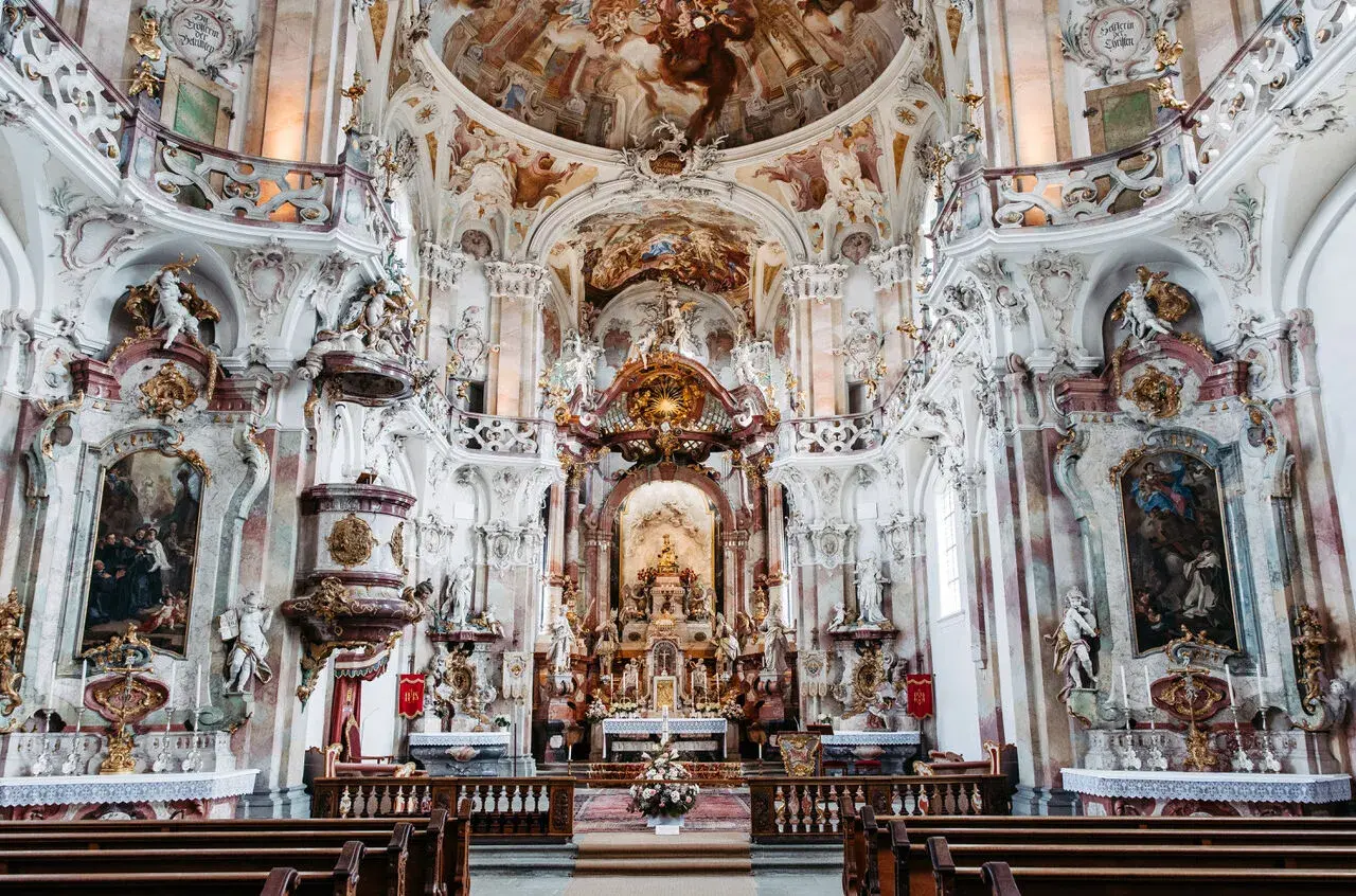 Prunkvolle Barockkirche im Kloster Mehrerau mit detailreichen Stuckaturen, Fresken und goldenen Verzierungen.