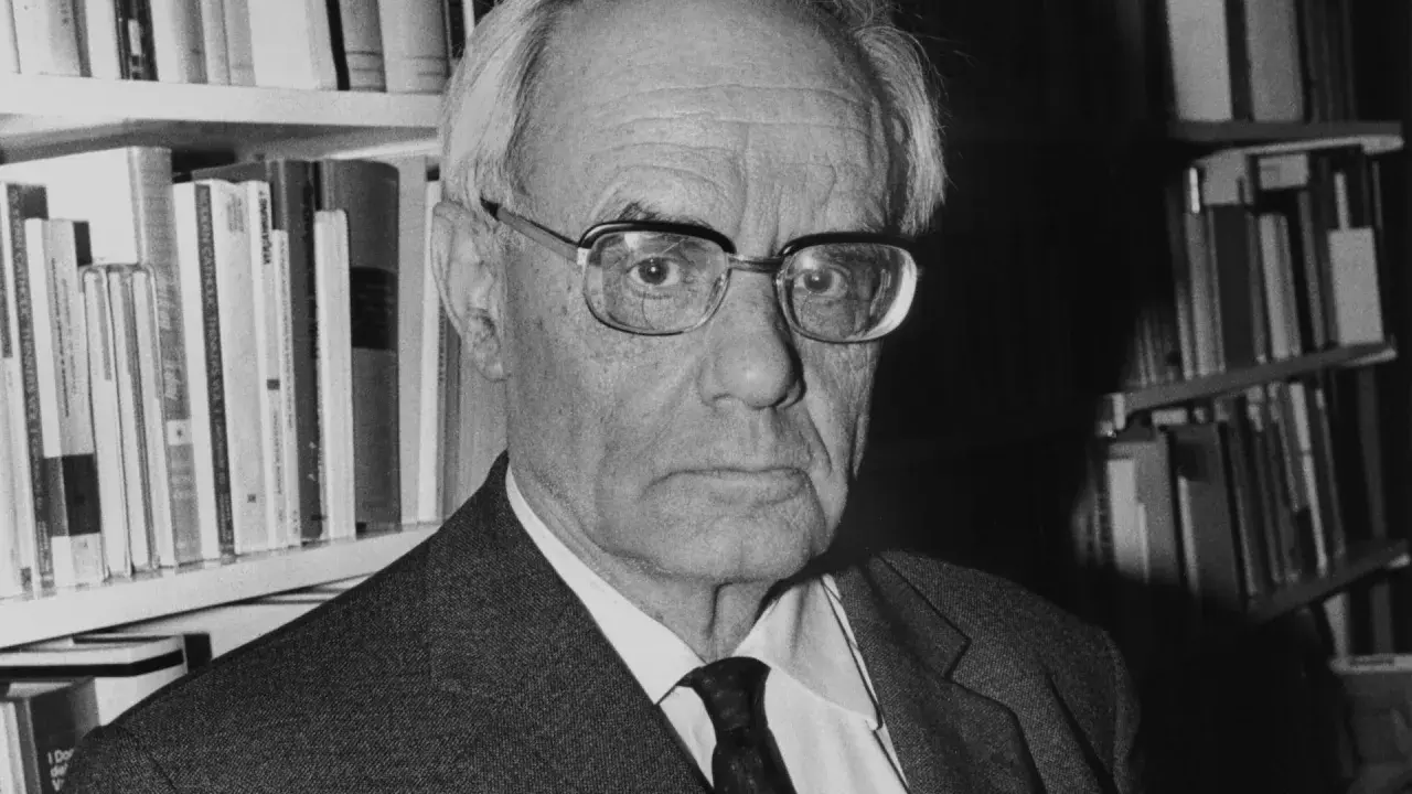 Porträt von Karl Rahner, dem bedeutenden katholischen Theologen, vor einem Bücherregal.