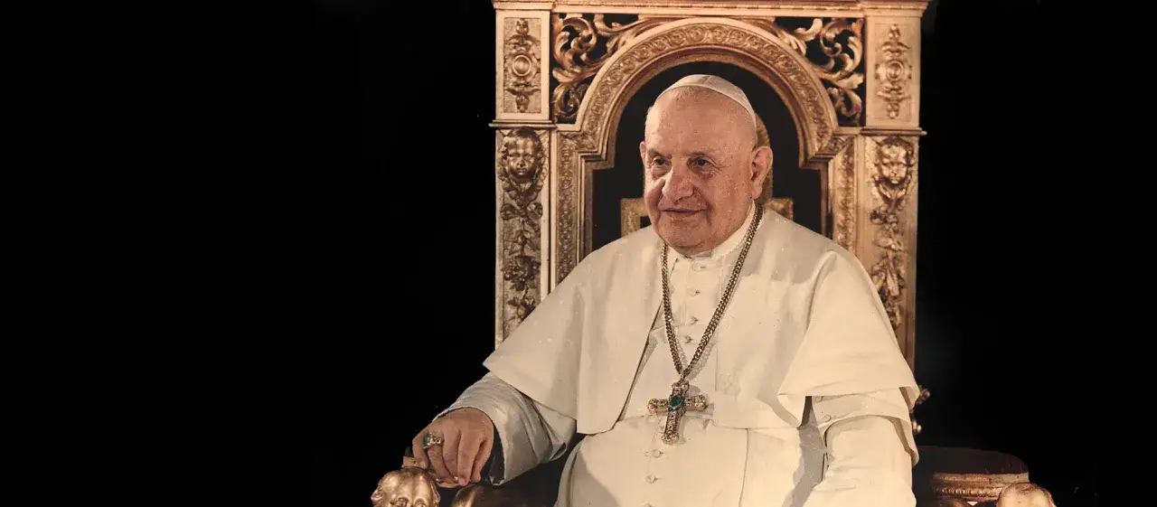 Papst Johannes XXIII. sitzt in einem prunkvollen Thron, tr&auml;gt ein wei&szlig;es Gewand und eine goldene Kette mit Kreuz.
