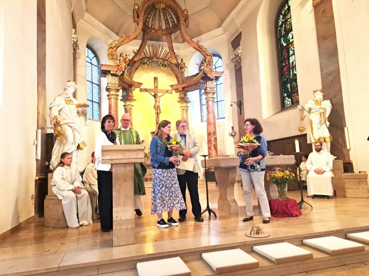 Feierliche Zeremonie in einer Kirche. Eine integrierte Gemeinde feiert mit Blumen und Geistlichen.