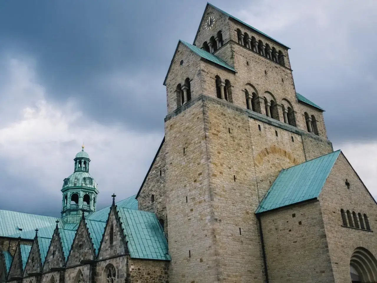 Der Dom St. Heinrich und Maria Janssen ragt unter dramatischem Himmel auf.