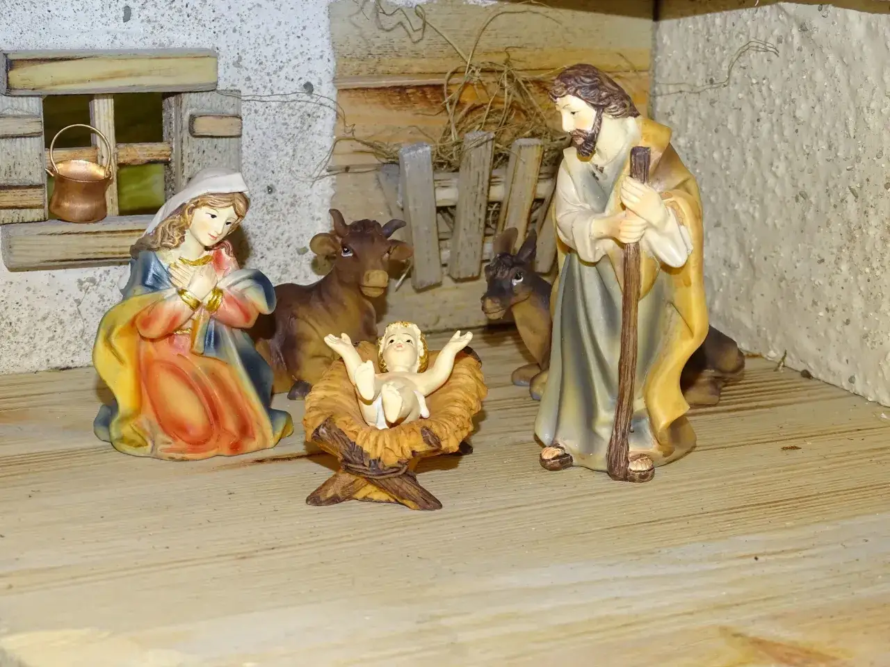 Maria und Josef bewundern das Jesuskind in der Krippe, umgeben von Ochs und Esel.