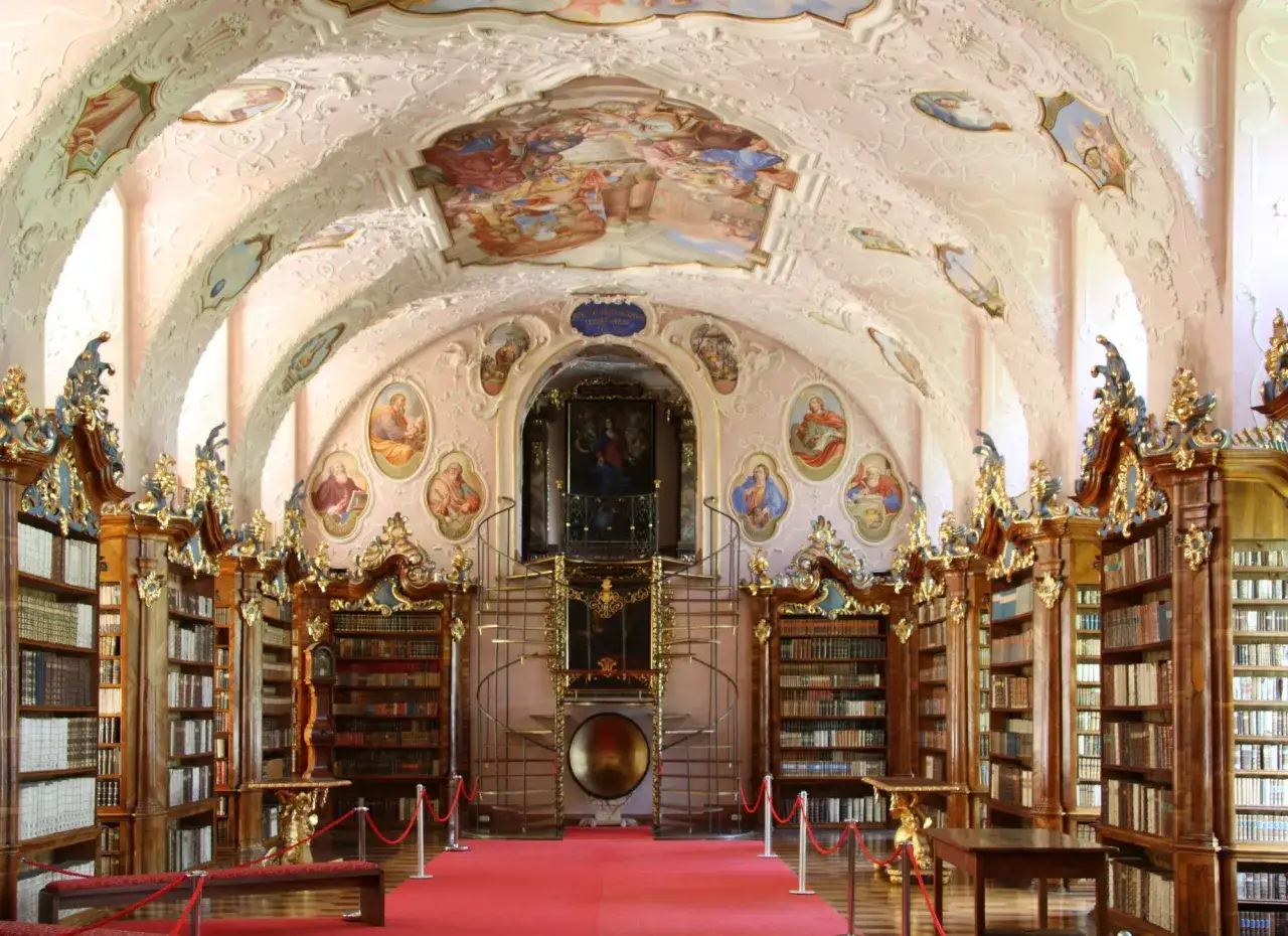 Prunkvolle Bibliothek im Stift Vorau mit Deckenmalereien, goldenen Verzierungen und endlosen B&uuml;cherregalen.