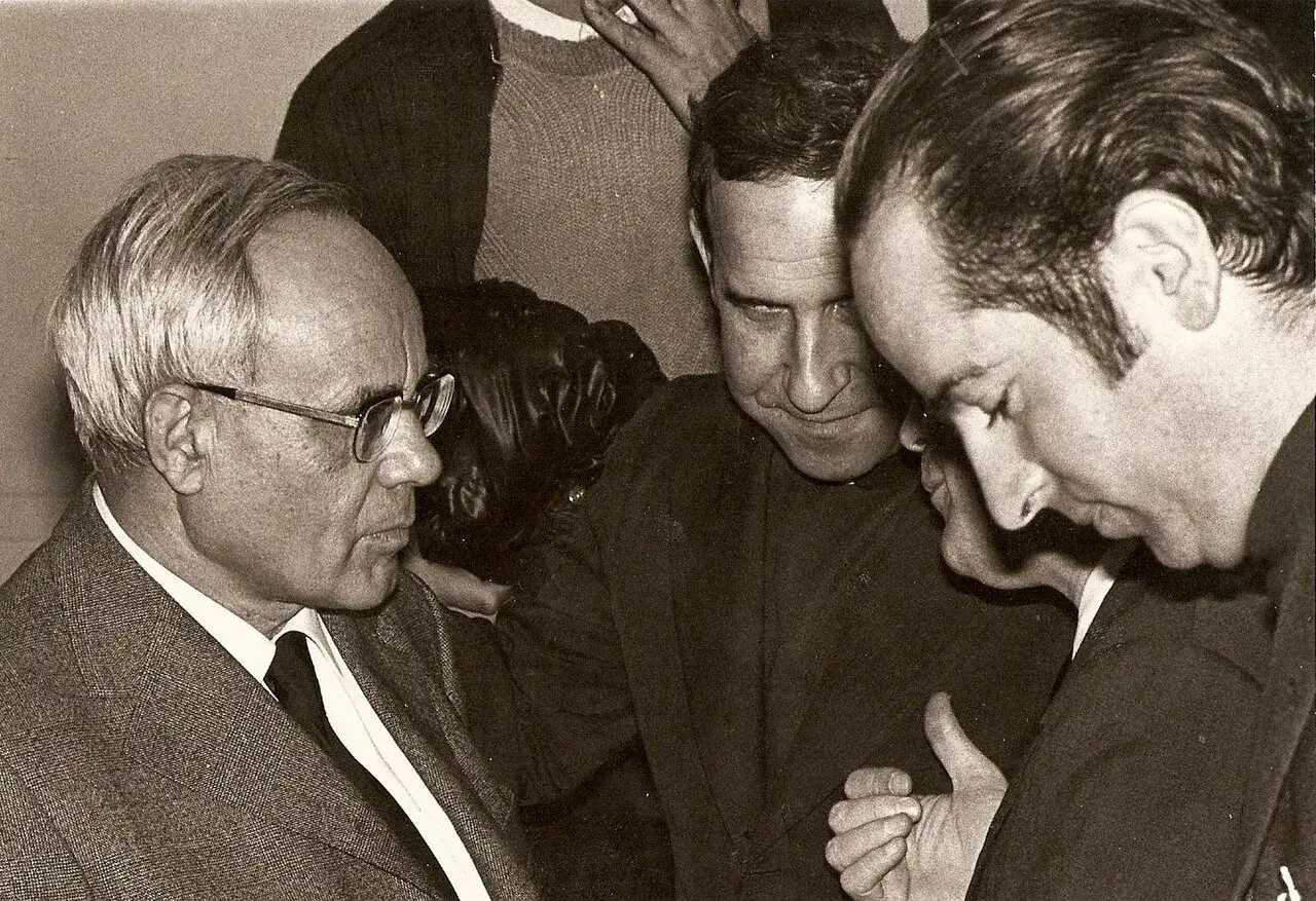 Karl Rahner im Gespr&auml;ch mit zwei M&auml;nnern. Sie wirken vertieft in eine Diskussion.