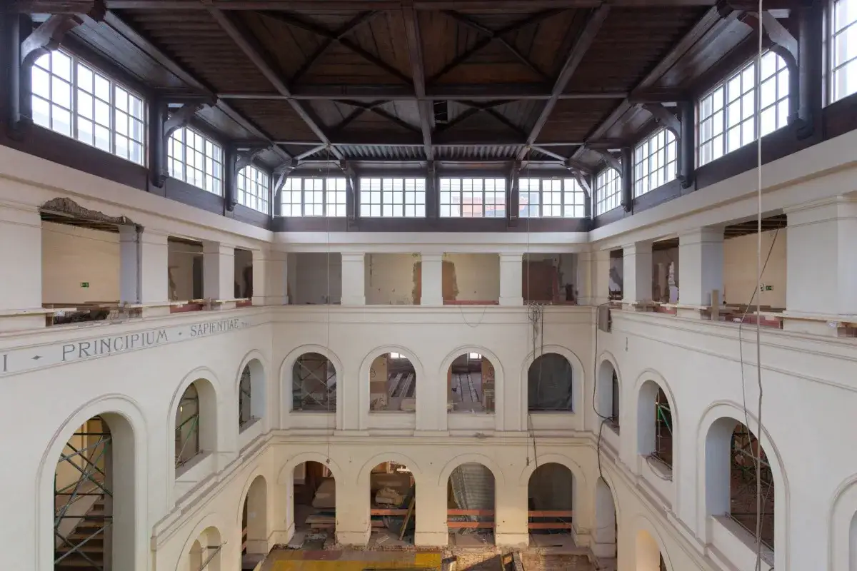 Innenansicht des Dombergs Freising im Umbau. Holzbalkendecke, Fensterfronten und Arkaden sind sichtbar.
