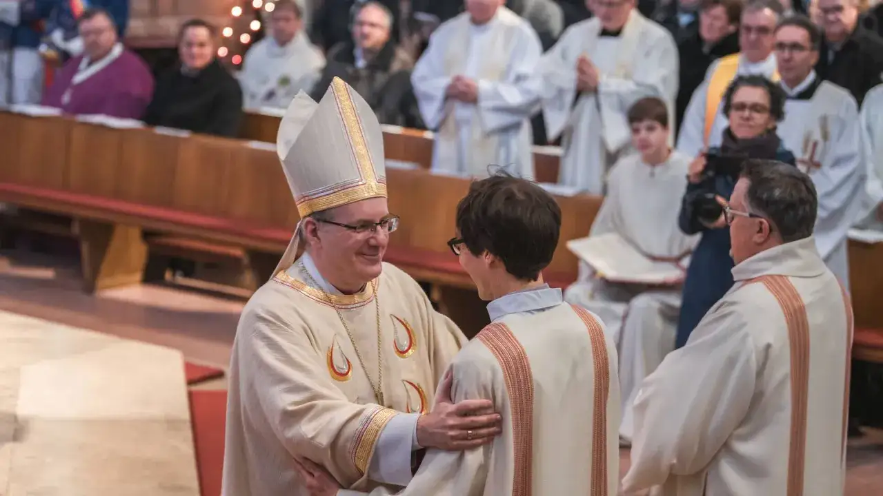 Bischof Thomas Frings umarmt einen Diakon in der Kirche.